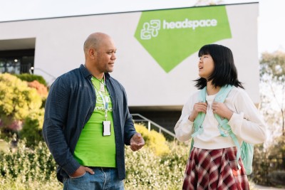 A headspace employee talking to a young person out the front of a headspace centre.