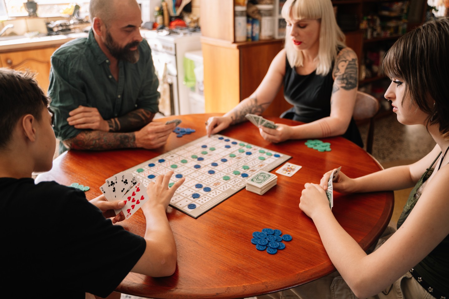 A family sitting at a table playing a board game.