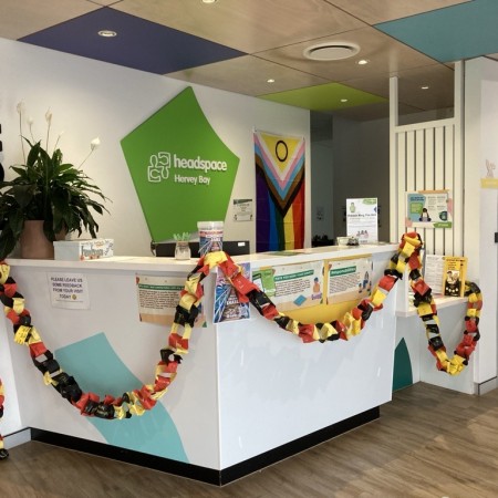 A photograph of headspace Hervey Bay foyer showing front counter and red, yellow and black bunting